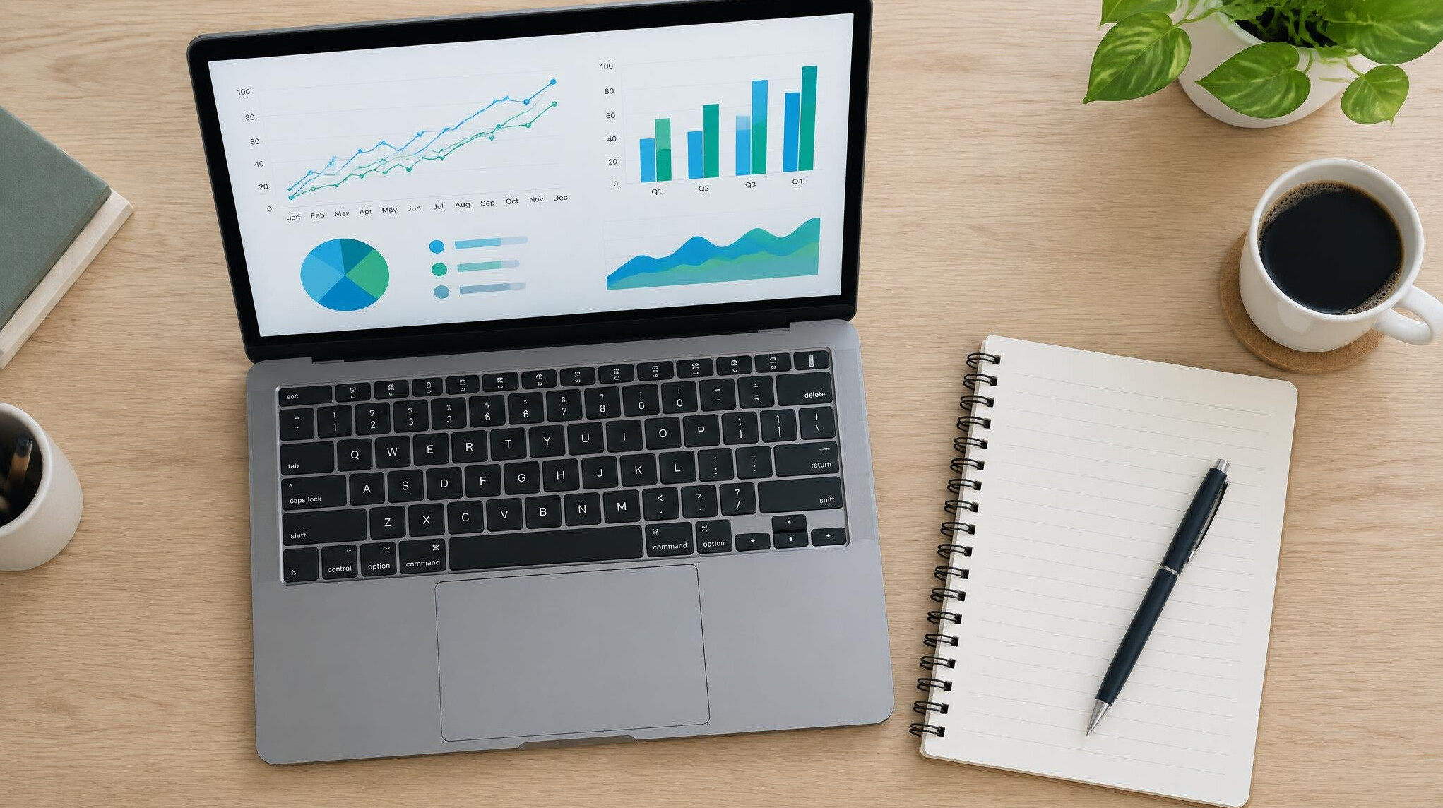 Laptop and notebook with charts on a desk